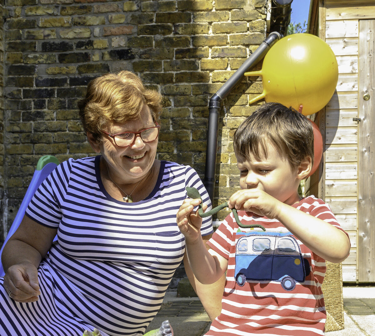 Young boy playing outside with toys